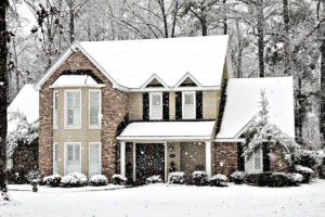 Brown and beige brick and siding home with a new roof covered in snow in Springfield, IL.