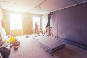Two home improvement contractors installing drywall in a residential home in Springfield, IL for a remodeling project.