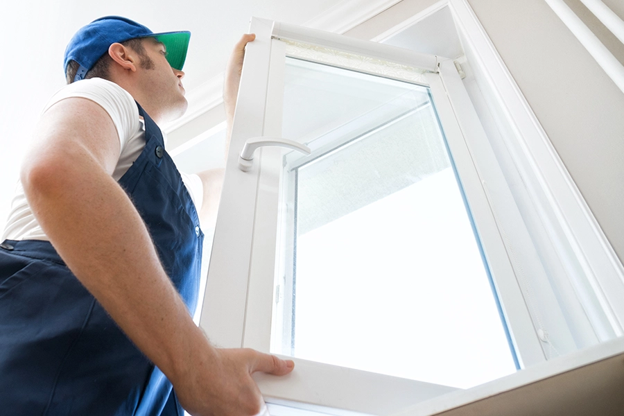 A man installing a new energy-efficient window in the home of a Springfield, IL resident.